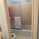 Newly renovated bathroom with walk-in shower, beige tile walls, and glass sliding doors, showcasing professional bathroom remodeling services by My Contracting Guy.