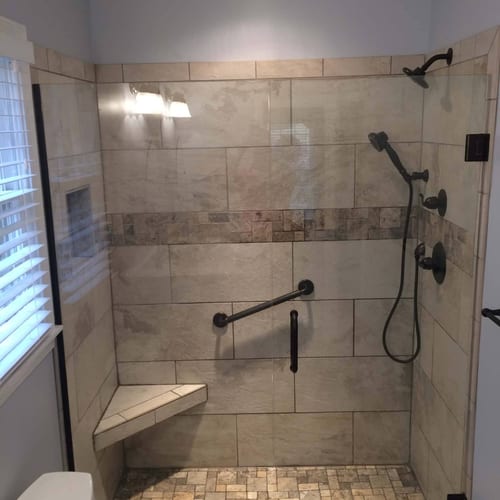 Shower remodel with tiled walls and walk-in accessibility features for senior-friendly bathroom installation.