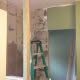 New bathroom remodeling under construction with drywall installation and green painted walls. Skilled contractor work for bathroom upgrades and renovation projects.