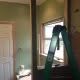 New home renovation project featuring wall demolition, green painted walls, and large window, showcasing professional construction services for residential remodeling and interior improvements.