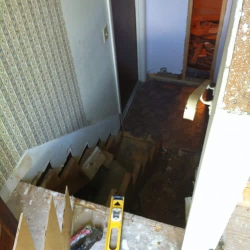 Newly renovated interior hallway under construction with exposed flooring and walls, featuring tools for home remodeling and repair by My Contracting Guy, specializing in residential renovations and contracting services.