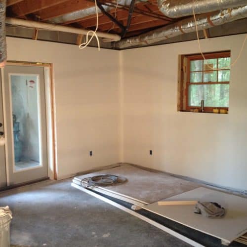 Newly renovated interior room during home construction, showing drywall work, electrical wiring, and window installation. Expert residential contracting services for remodeling and renovation projects.