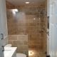 Bathroom shower renovation with natural stone tiles and glass enclosure - expert contracting and remodeling services.