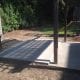 Modern concrete patio with a wooden deck and playground equipment, ideal for outdoor family activities and relaxation, custom-built by My Contracting Guy.