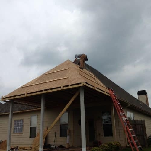 New roof installation in progress on a residential house with professional contractors working on the roof.