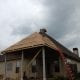 New roof installation in progress on a residential house with professional contractors working on the roof.