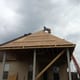 New roof installation on a house with a worker placing shingles, showcasing quality roofing services by My Contracting Guy.